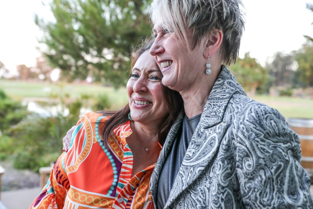 Two women CEOs embrace one another